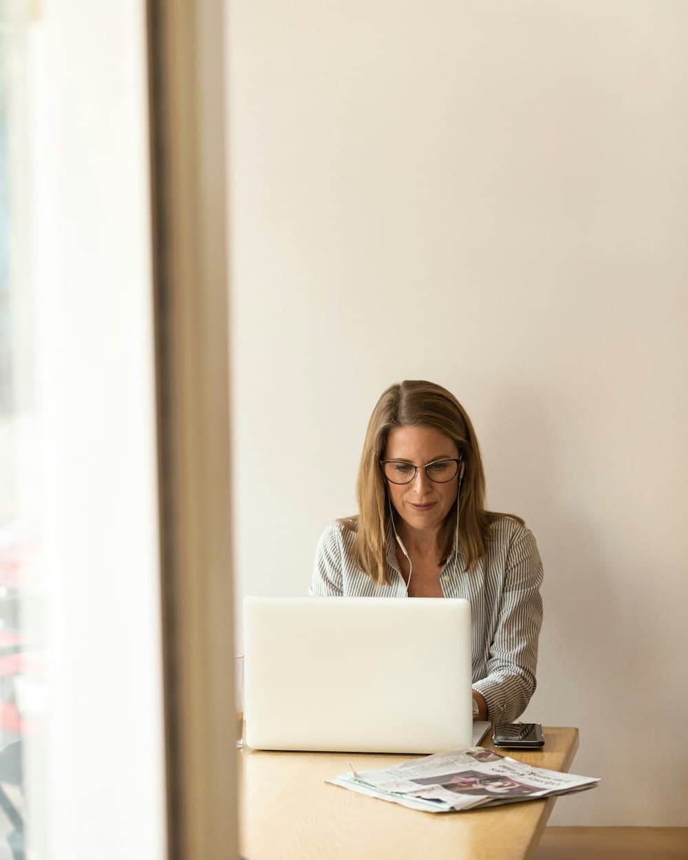 A woman working late on a laptop at a wooden table
