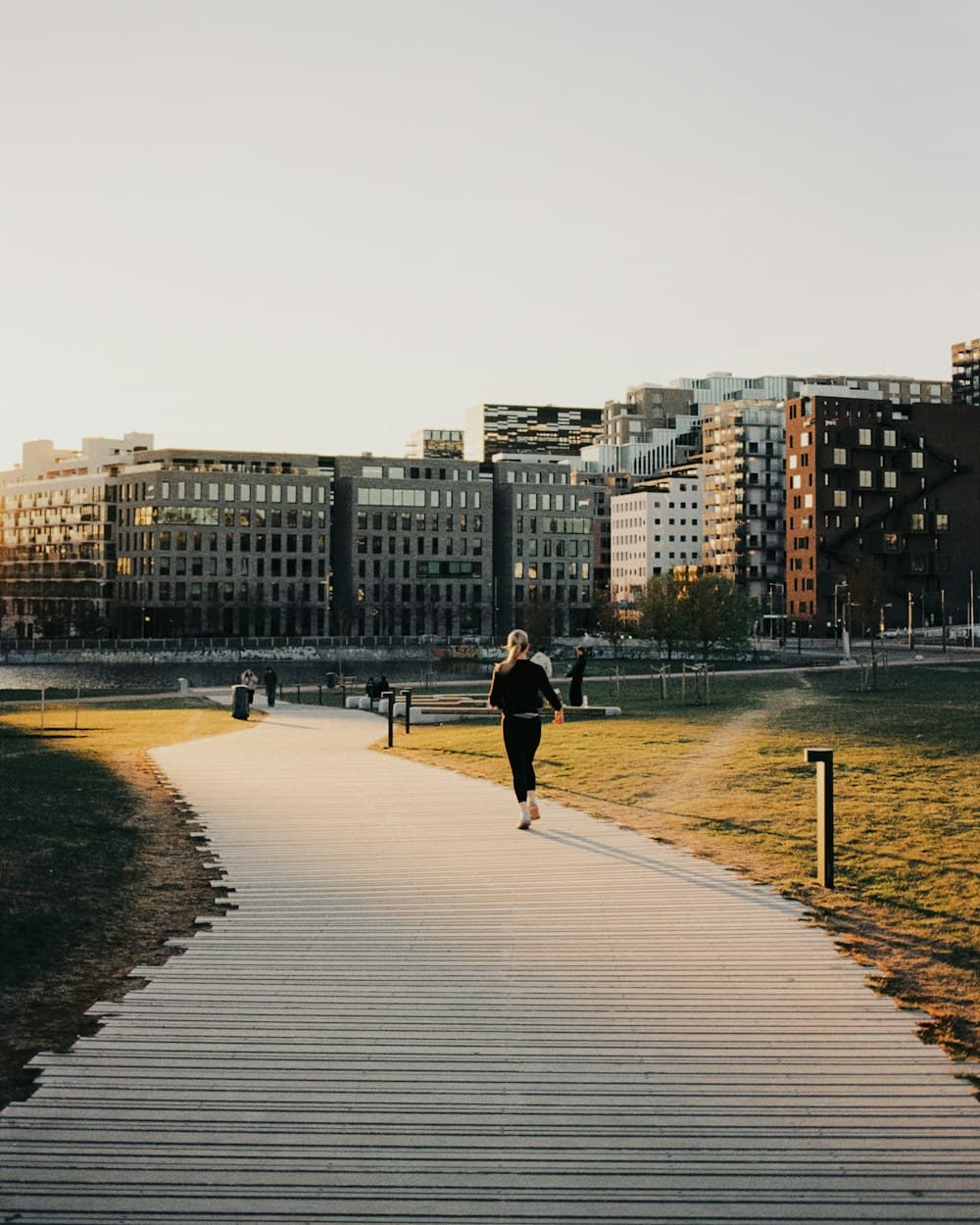 A person running along a park path at sunset